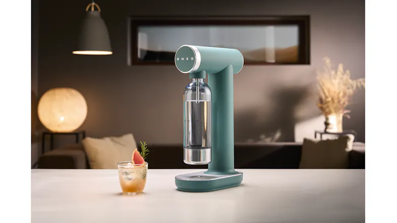 Lifestyle image of the matte emerald green Smeg Sparkling Water Maker on a kitchen counter Lifestyle image of the matte emerald green Smeg Sparkling Water Maker on a kitchen counter