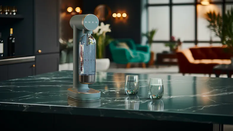 Lifestyle image of the Smeg Sparkling Water Maker in use on a kitchen island Lifestyle image of the Smeg Sparkling Water Maker in use on a kitchen island