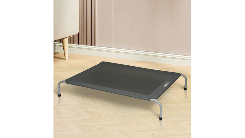 Front angled view of black raised mesh pet cot with silver steel legs on a timber floor Front angled view of black raised mesh pet cot with silver steel legs on a timber floor