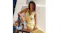 A woman holding a BURGA striped phone case and matching headphones accessory paired with a flowing yellow outfit A woman holding a BURGA striped phone case and matching headphones accessory paired with a flowing yellow outfit