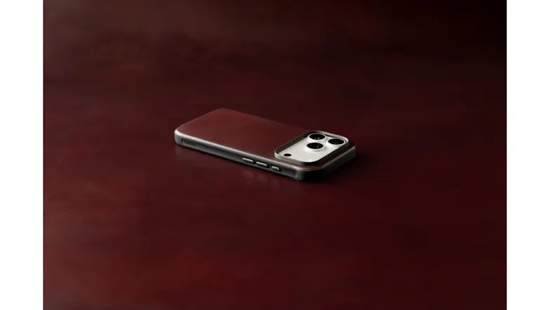 Side edge view of Nomad brown leather iPhone 18 Pro case showing tactile metal volume buttons Side edge view of Nomad brown leather iPhone 18 Pro case showing tactile metal volume buttons