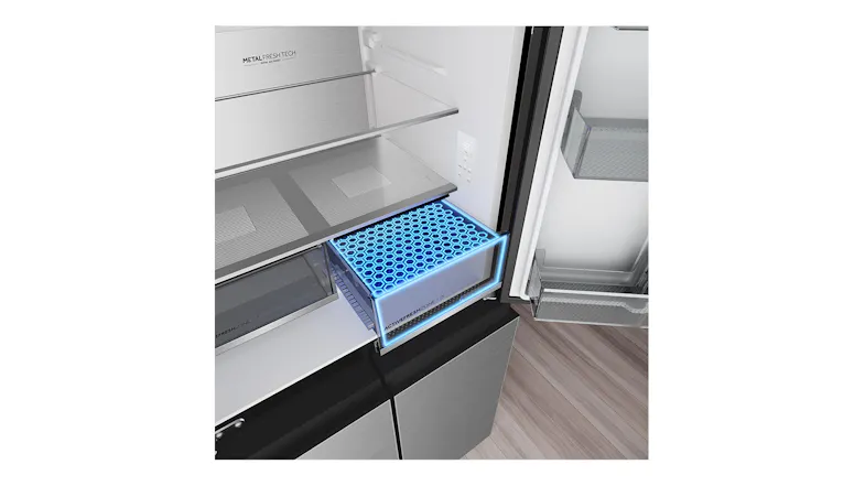 Close-up interior view of the Haier 500 Series refrigerator’s crisper drawer with a blue freshness filter panel and glass shelving Close-up interior view of the Haier 500 Series refrigerator’s crisper drawer with a blue freshness filter panel and glass shelving