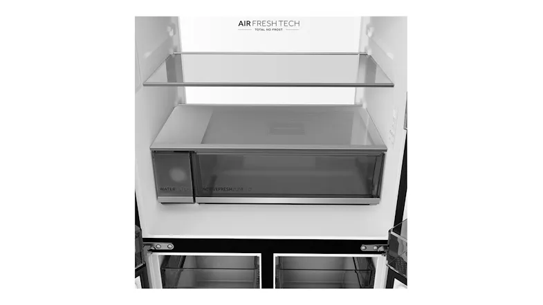 Close-up of a refrigerator interior with glass shelves, a humidity crisper drawer, and a built-in water filter compartment Close-up of a refrigerator interior with glass shelves, a humidity crisper drawer, and a built-in water filter compartment