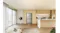 Wide-angle view of a silver Haier four-door refrigerator recessed into modern beige kitchen cabinetry Wide-angle view of a silver Haier four-door refrigerator recessed into modern beige kitchen cabinetry