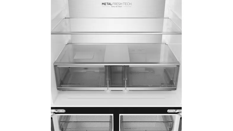Interior view of a silver Haier refrigerator with glass shelves and three transparent crisper drawers Interior view of a silver Haier refrigerator with glass shelves and three transparent crisper drawers