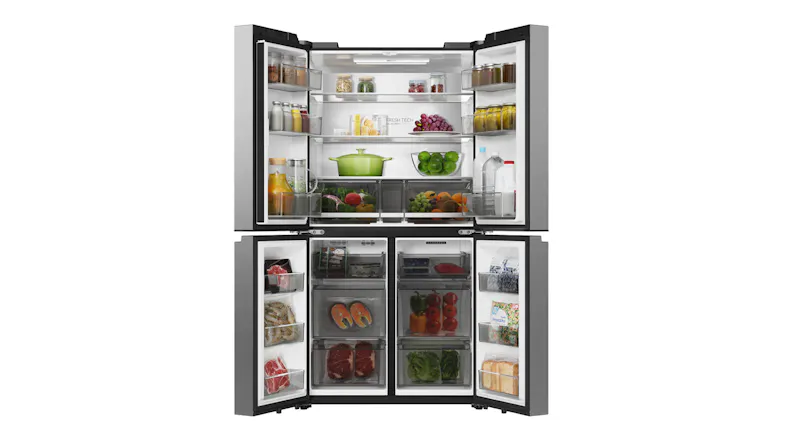 Open silver Haier quad-door refrigerator stocked with fresh produce, drinks, and frozen food Open silver Haier quad-door refrigerator stocked with fresh produce, drinks, and frozen food