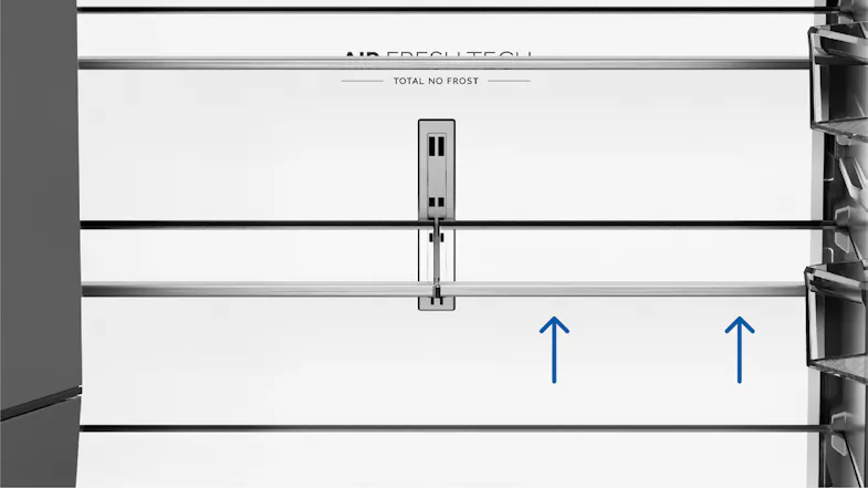 Close-up interior view of a refrigerator with adjustable glass shelves and a central airflow vent panel Close-up interior view of a refrigerator with adjustable glass shelves and a central airflow vent panel