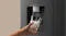 Close-up view of a black refrigerator water dispenser dispensing water and ice into a clear drinking glass Close-up view of a black refrigerator water dispenser dispensing water and ice into a clear drinking glass