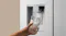Close-up of a silver refrigerator water dispenser filling a clear drinking glass with ice water Close-up of a silver refrigerator water dispenser filling a clear drinking glass with ice water