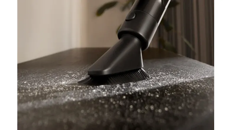 Vacuum cleaning under furniture showing low profile Vacuum cleaning under furniture showing low profile
