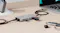 Space grey USB-C hub connected to a laptop on a desk, with multiple USB-C devices and a flash drive attached Space grey USB-C hub connected to a laptop on a desk, with multiple USB-C devices and a flash drive attached