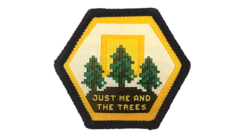 Close-Up View of a yellow hexagon patch with pixel-style trees, a black border, and embroidered details Close-Up View of a yellow hexagon patch with pixel-style trees, a black border, and embroidered details