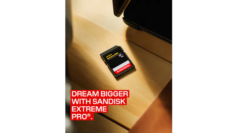 Angled view of a SanDisk Extreme PRO SD Card on a wooden desk beside electronic devices Angled view of a SanDisk Extreme PRO SD Card on a wooden desk beside electronic devices