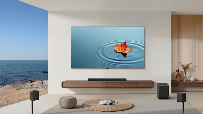 Front view of a modern living room with a wall-mounted TCL TV, soundbar, wireless speakers, and subwoofer Front view of a modern living room with a wall-mounted TCL TV, soundbar, wireless speakers, and subwoofer