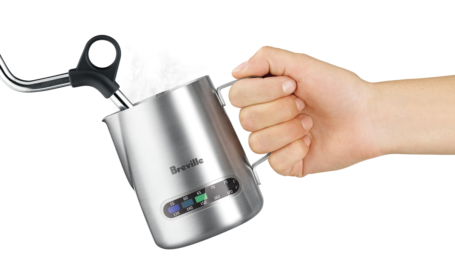 A close-up shot of a hand holding a milk jug while using a milk frother.
