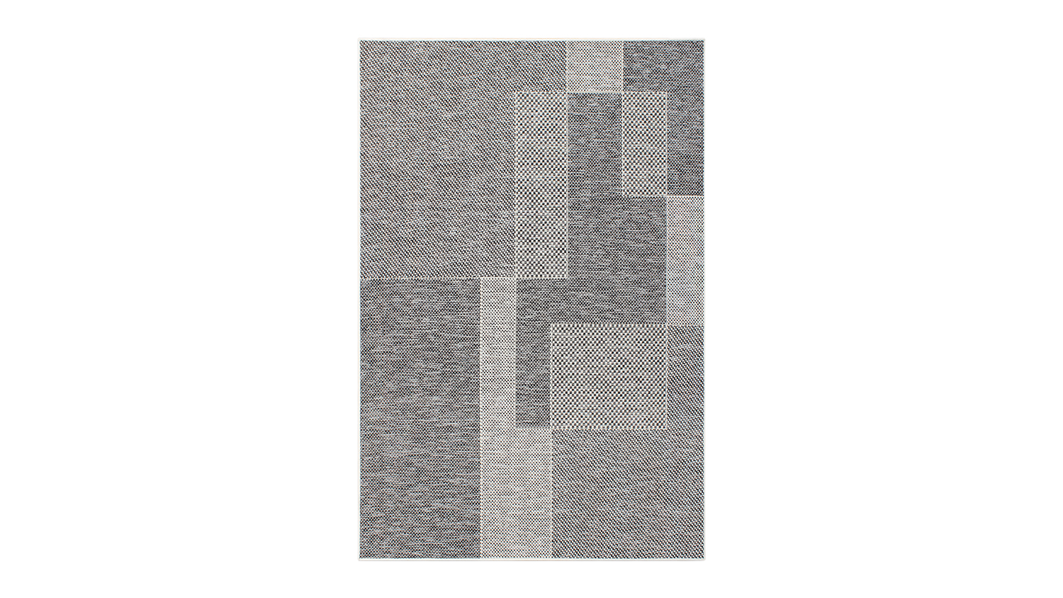 Angled view of the outdoor rug showing its bold geometric design in black, white, and grey