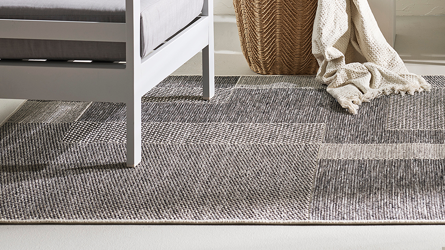 Interior setting with furniture on the rug, showing its texture and geometric design in daylight