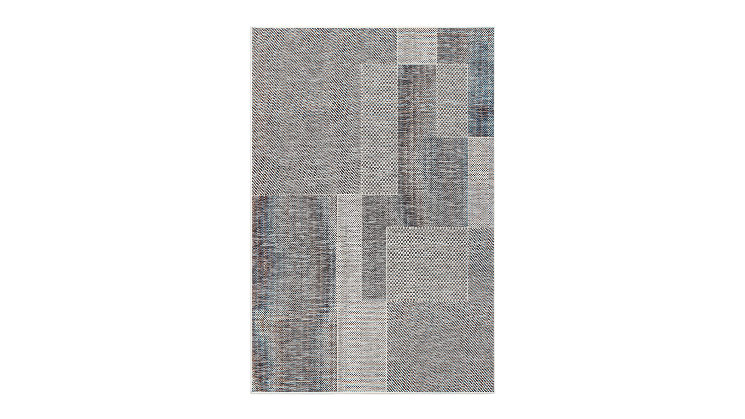 Angled view of the outdoor rug showing its bold geometric design in black, white, and grey