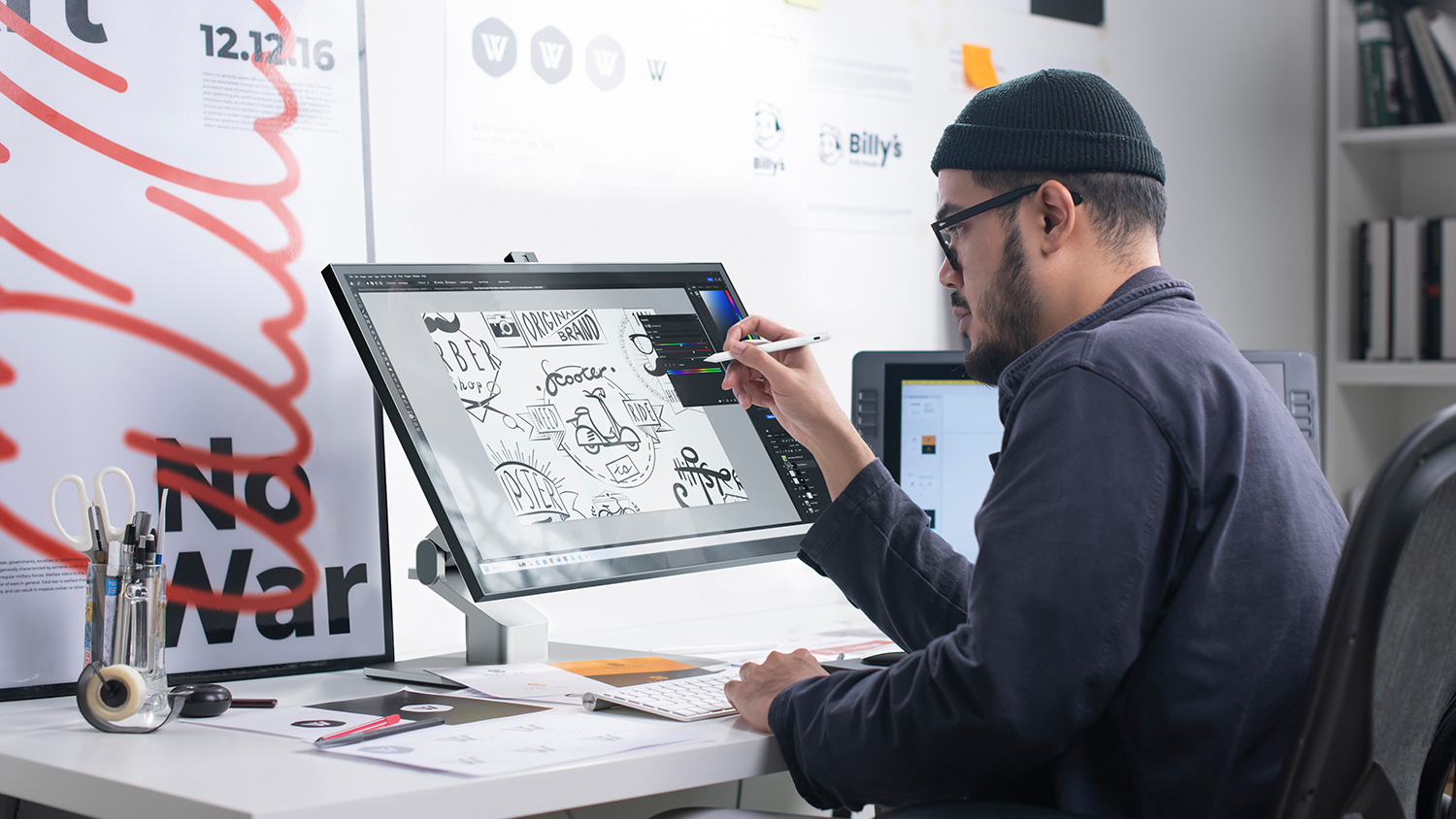 A designer sketching on a monitor held by Alogic stand.