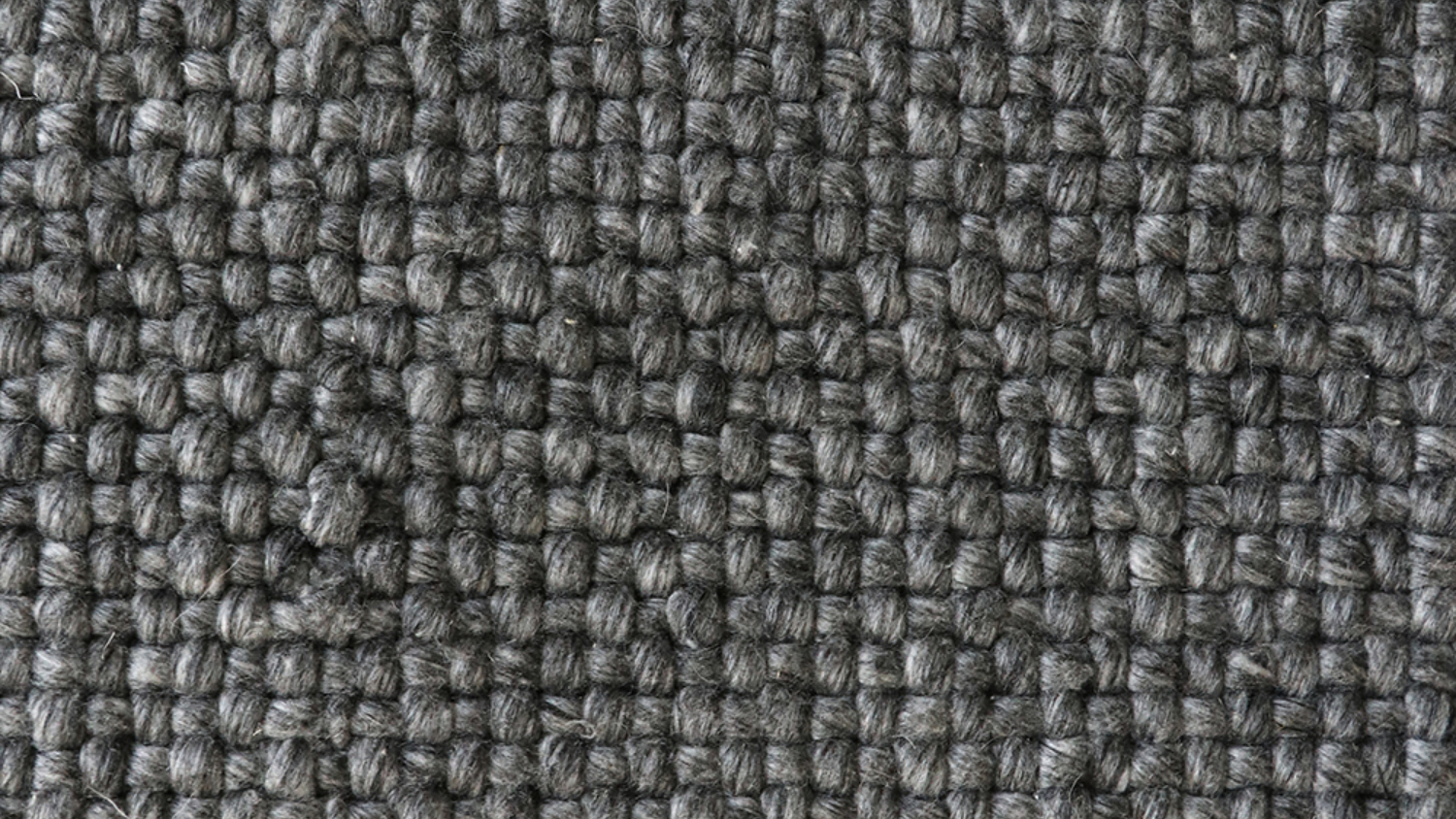 A close-up picture of a charcoal-coloured woven rug.