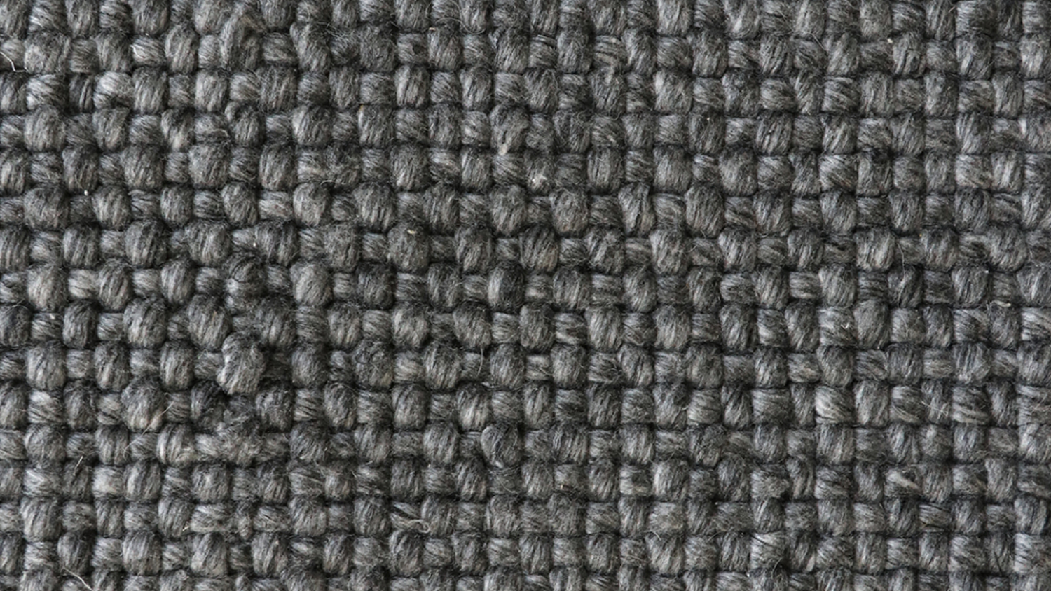 A close-up picture of a charcoal-coloured woven rug.