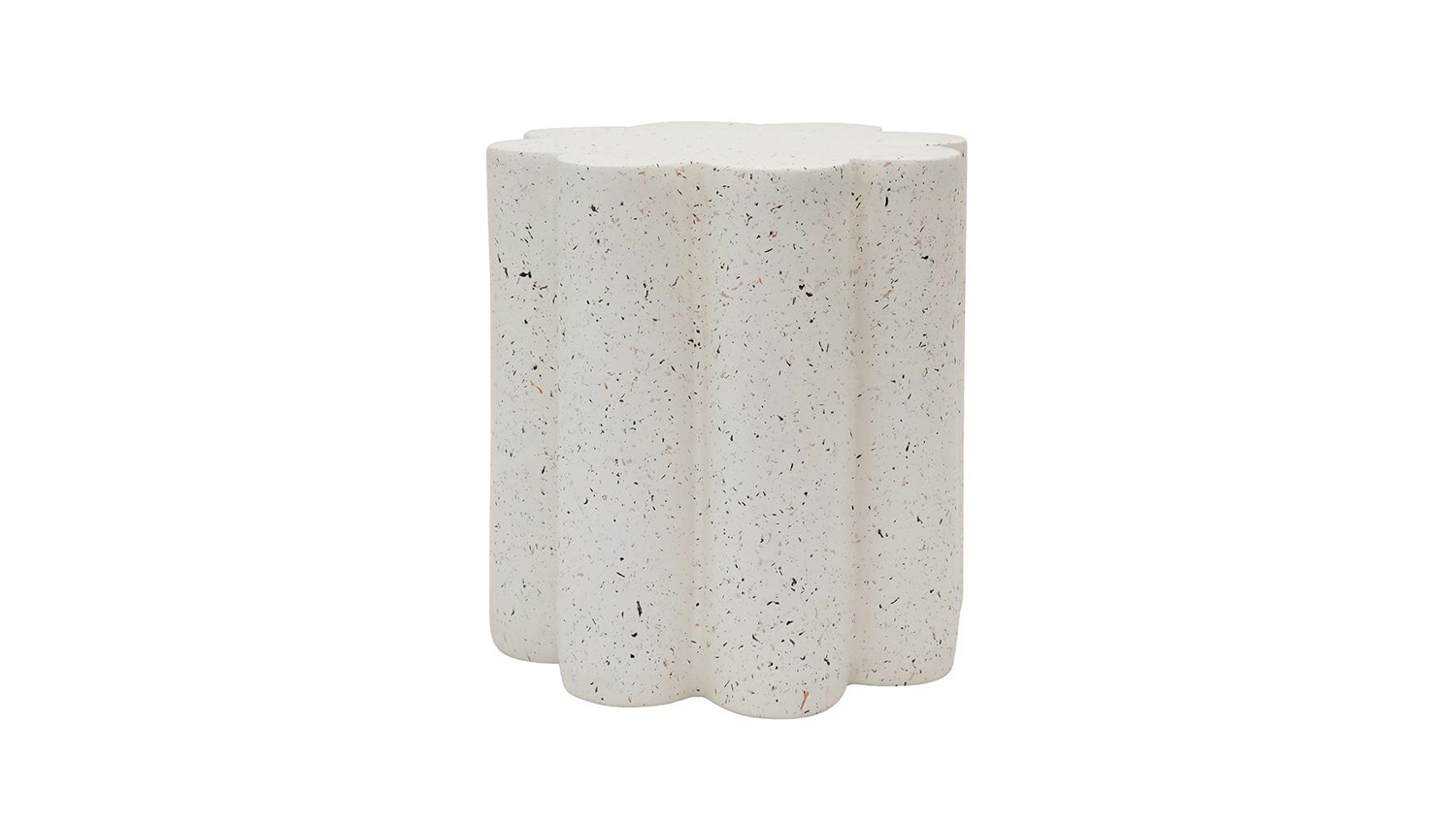 The flower-shaped side table features scalloped edges and a white flecked terrazzo-style finish.