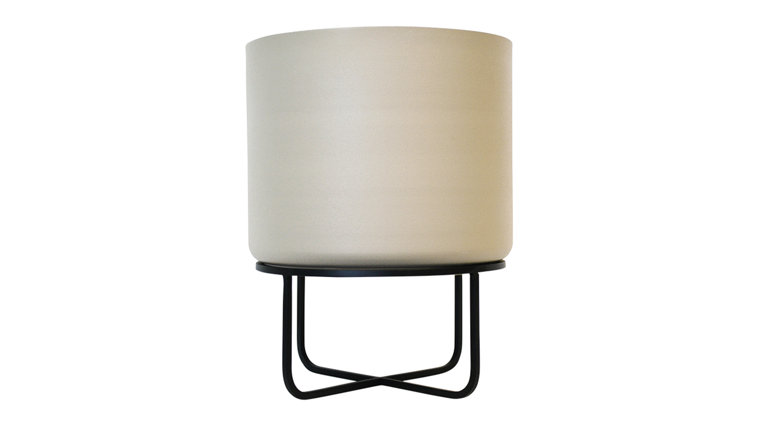 A beige Asher planter on a modern black metal stand with crossed legs