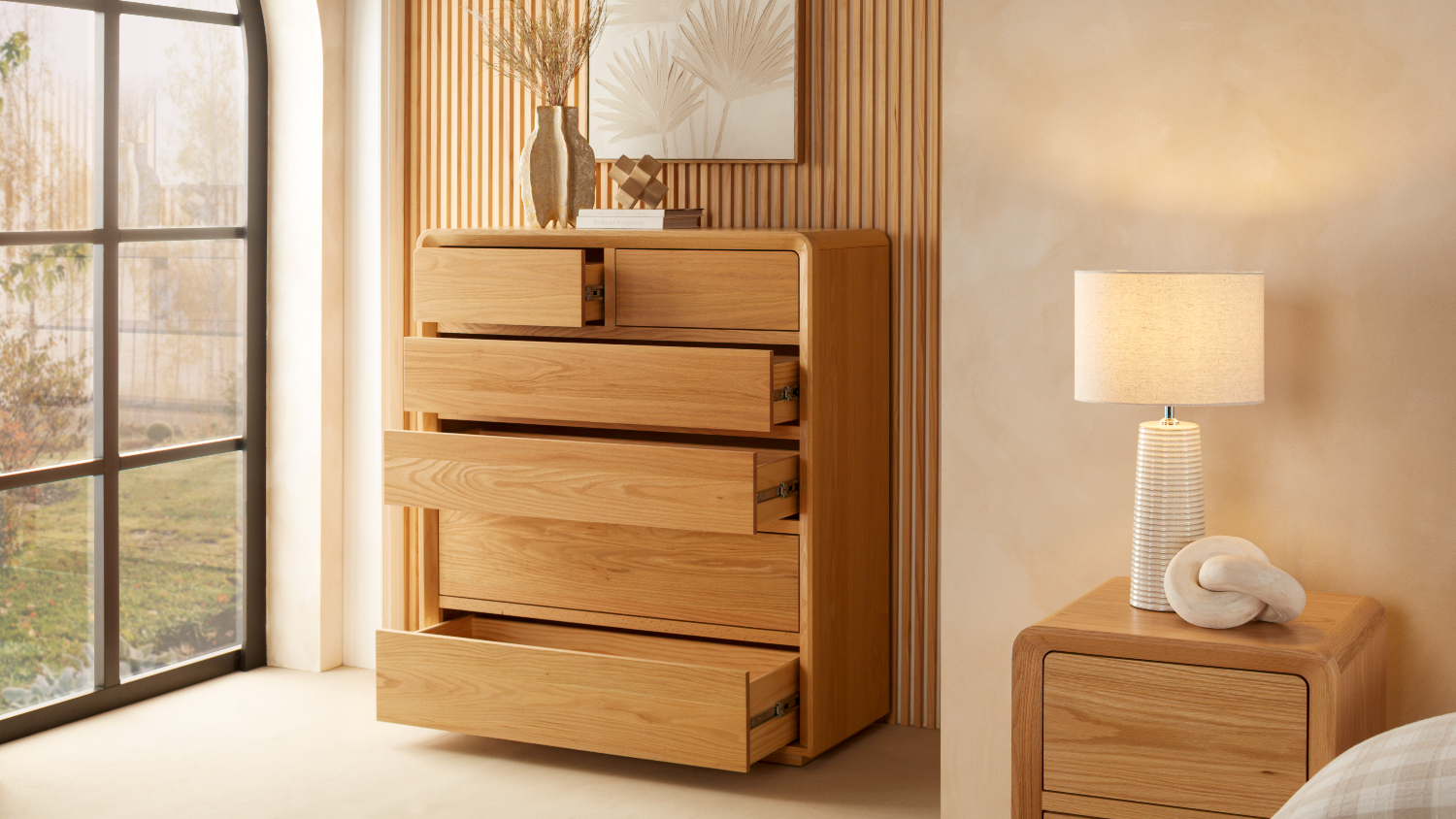 A wooden tallboy with four drawers open.