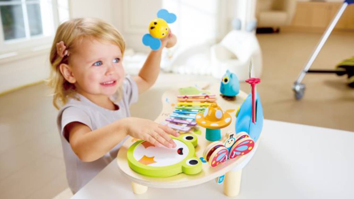 A colourful wooden children's toy with a rainbow xylophone, animal figures.