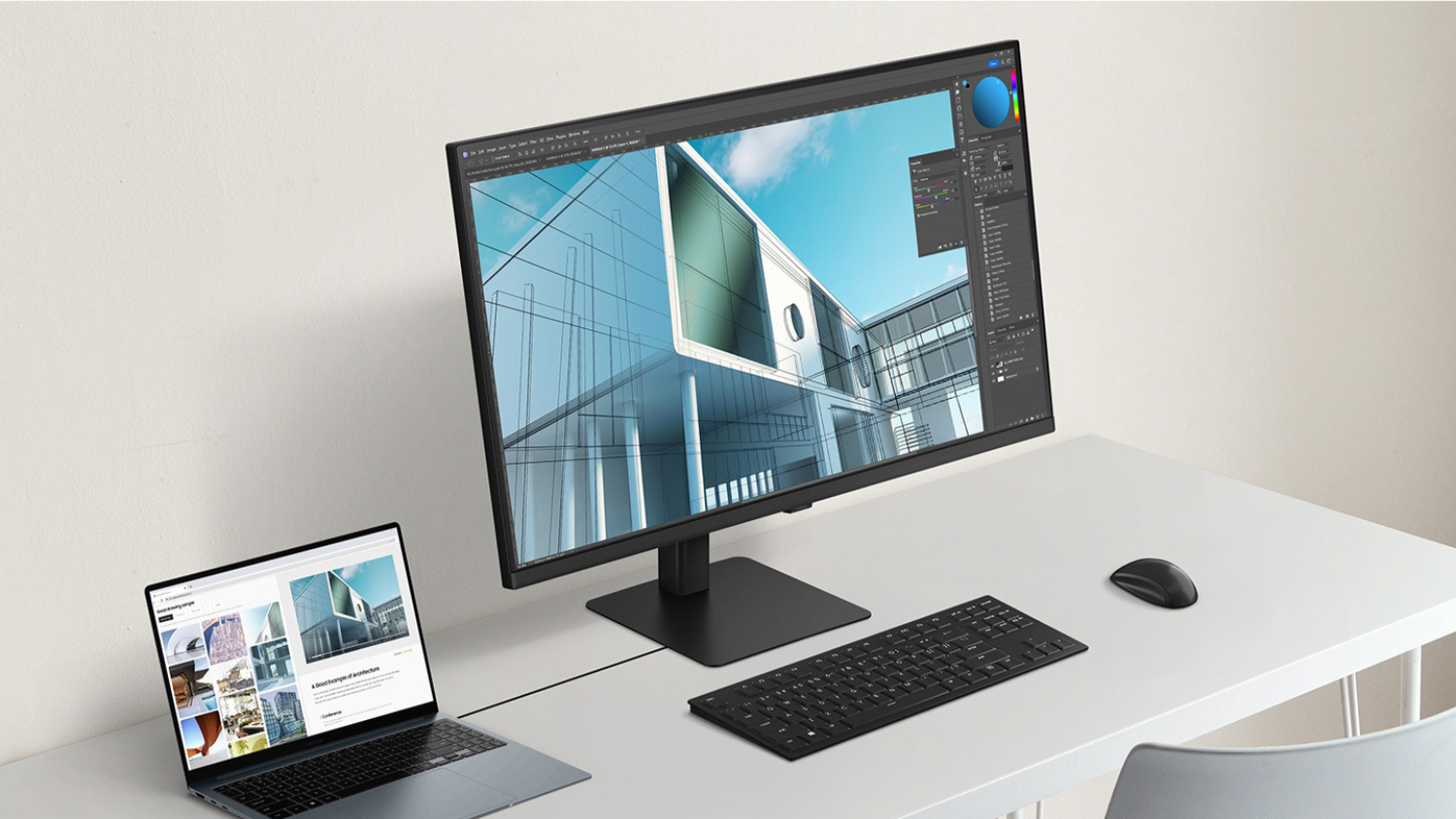 A modern office setup with a monitor, laptop, keyboard, and mouse.