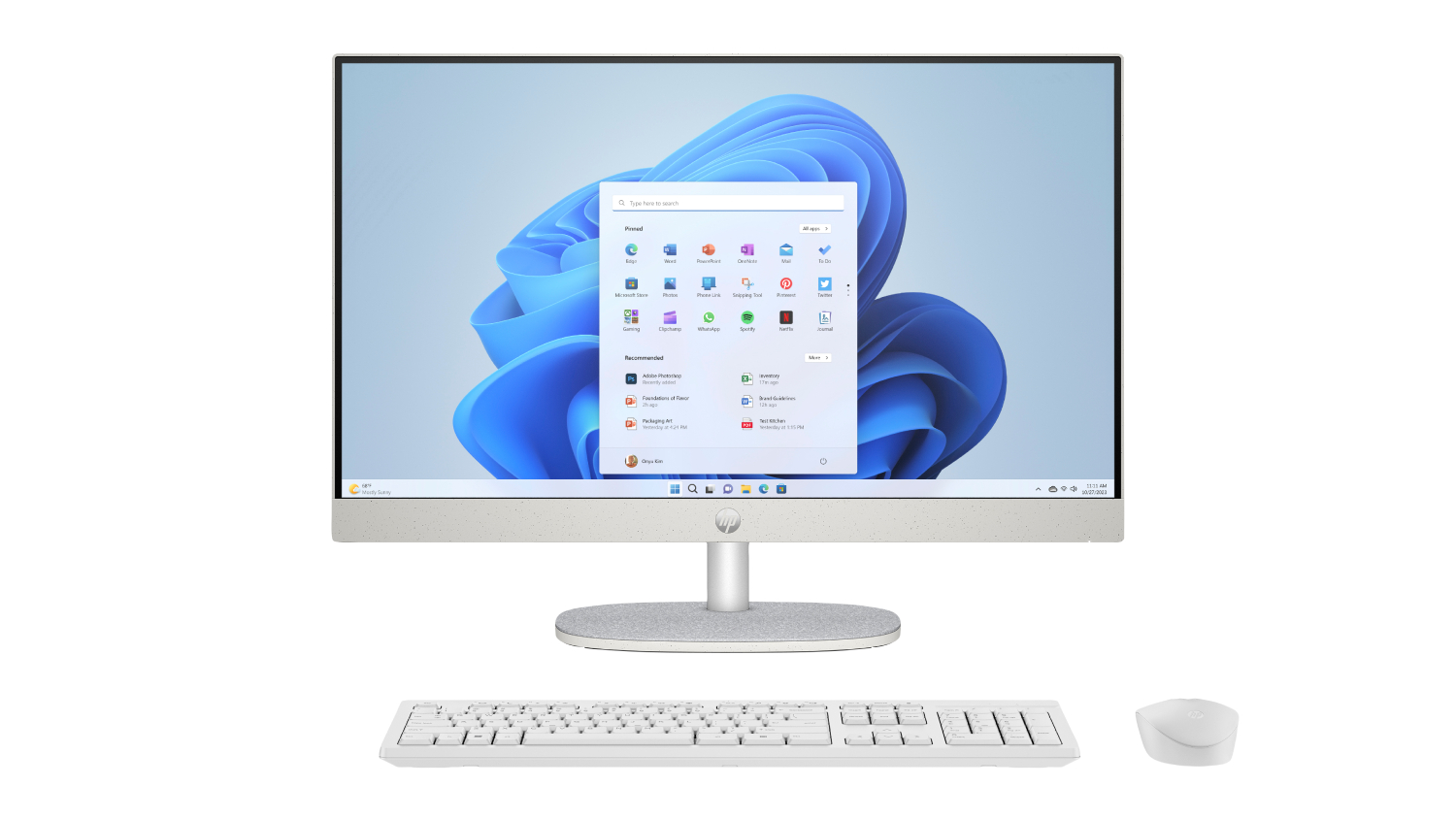 A front view of a white HP desktop computer with a raised webcam, paired with a wired keyboard and mouse.