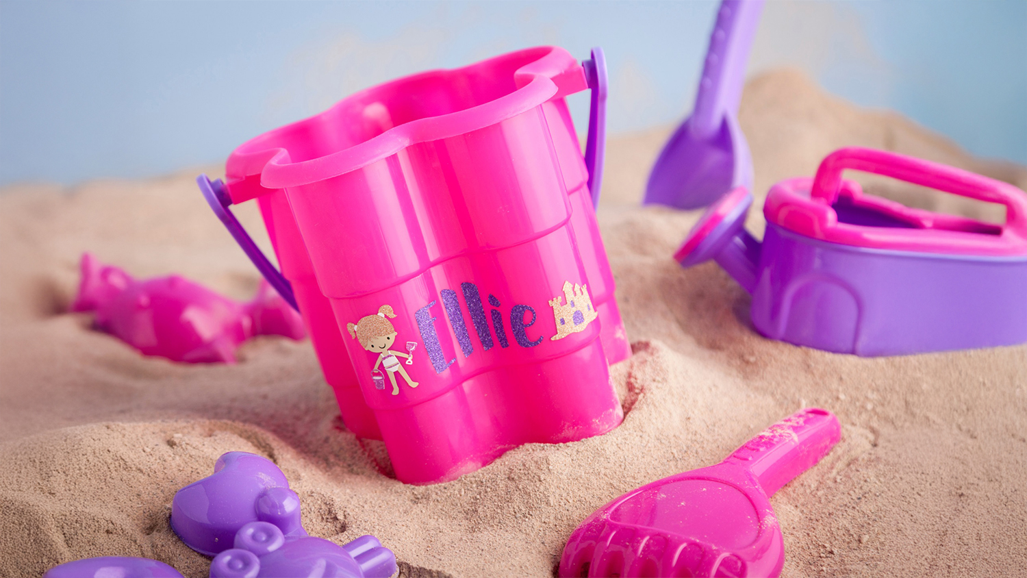 A pink sand bucket with a child's name on it, demonstrating the vinyl’s non-toxic design.