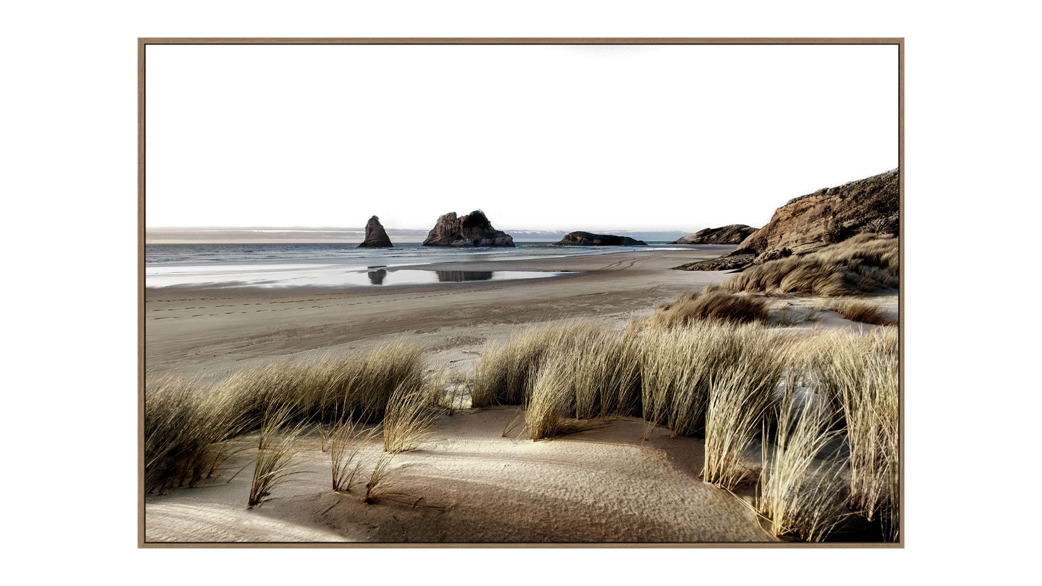 A framed wall art of Wharaiki Beach with dancing dunes and rock formations.