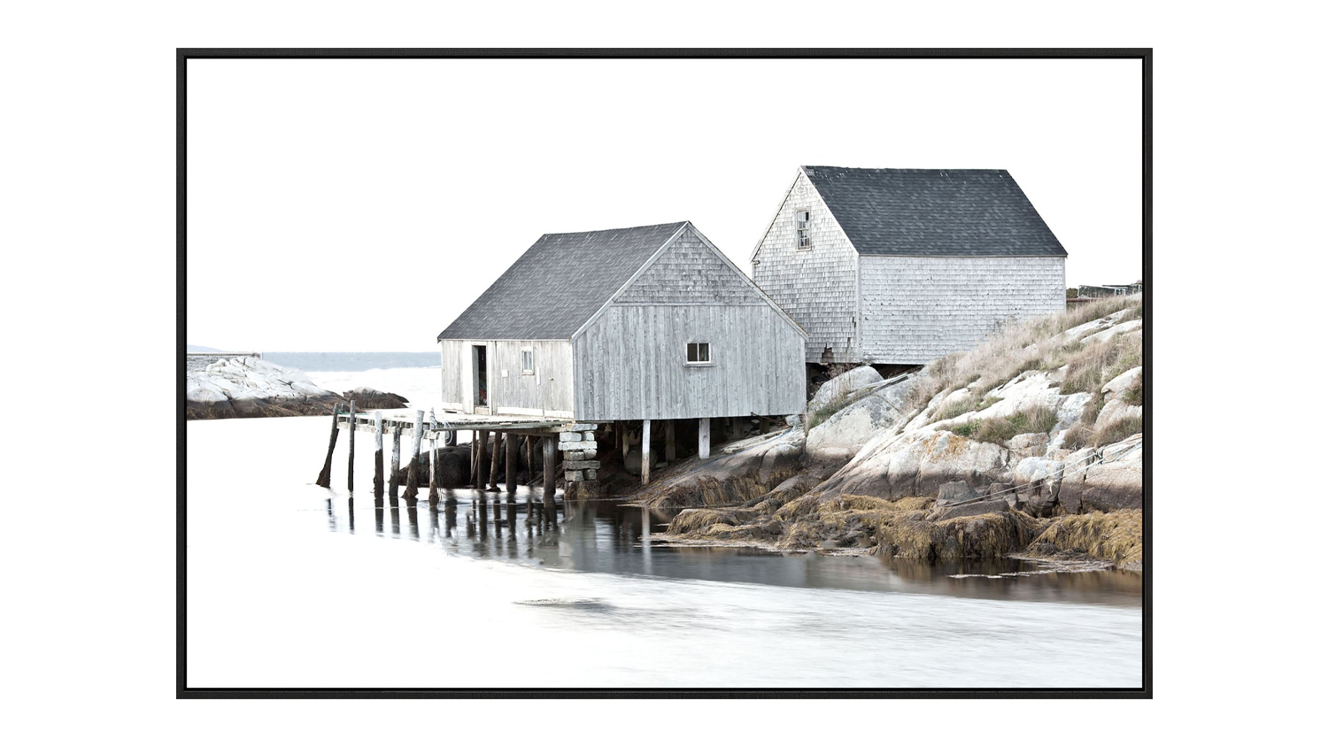A framed canvas showing two rustic wooden boatsheds