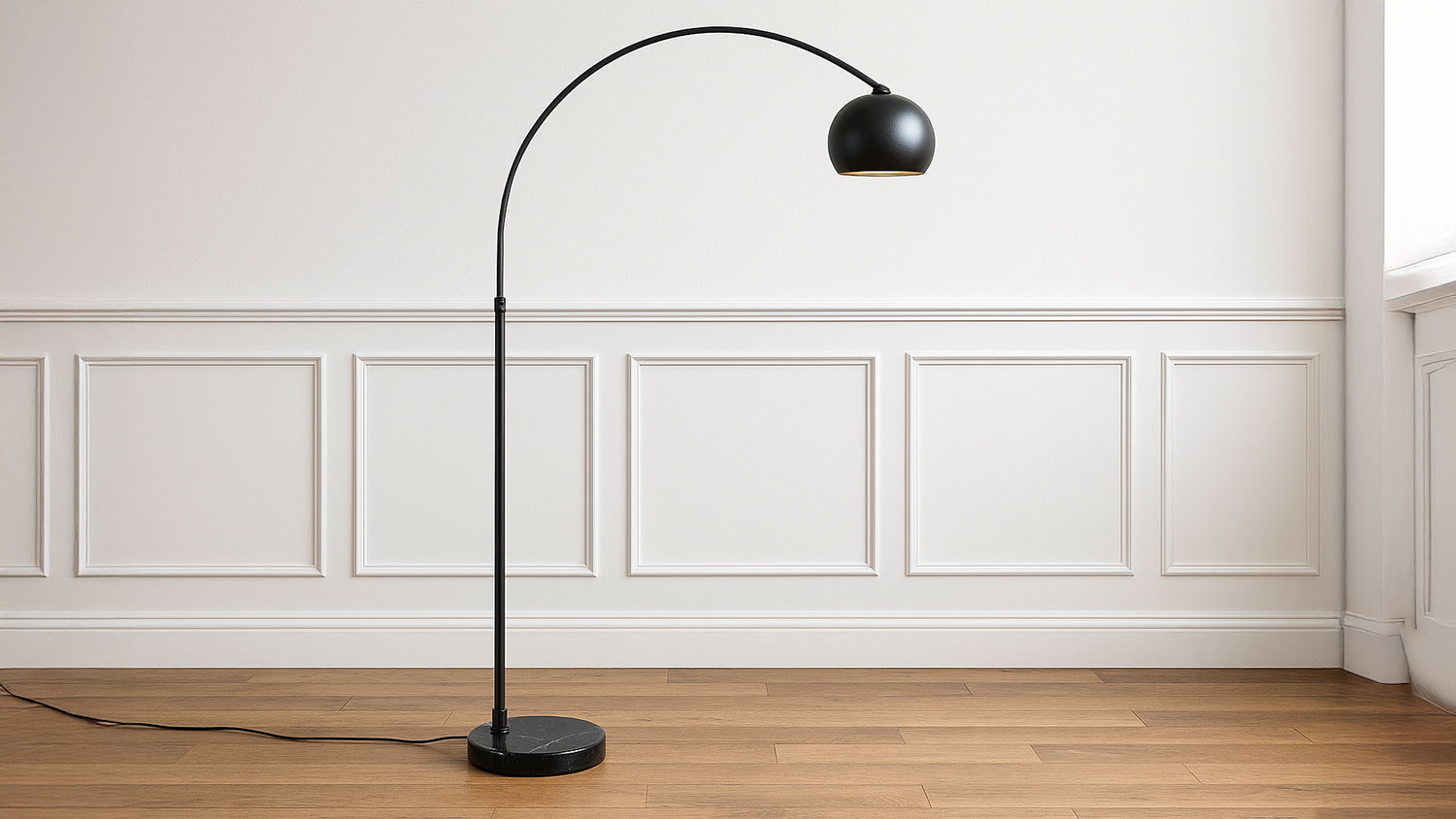 A modern black floor lamp with a curved arm and dome-shaped shade