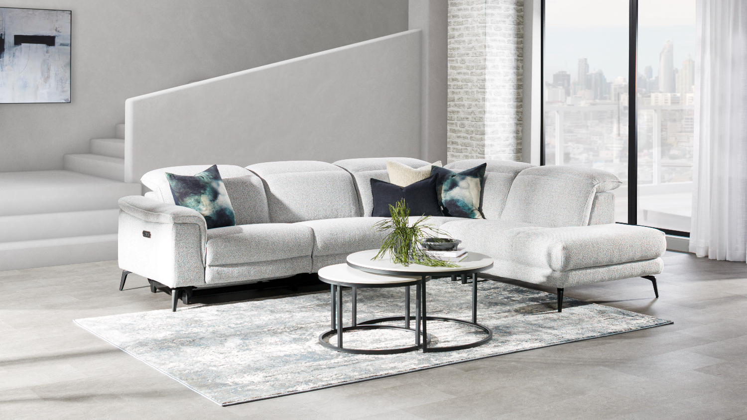 Modern grey reclining sofa with manual headrests and an extended chaise at the end