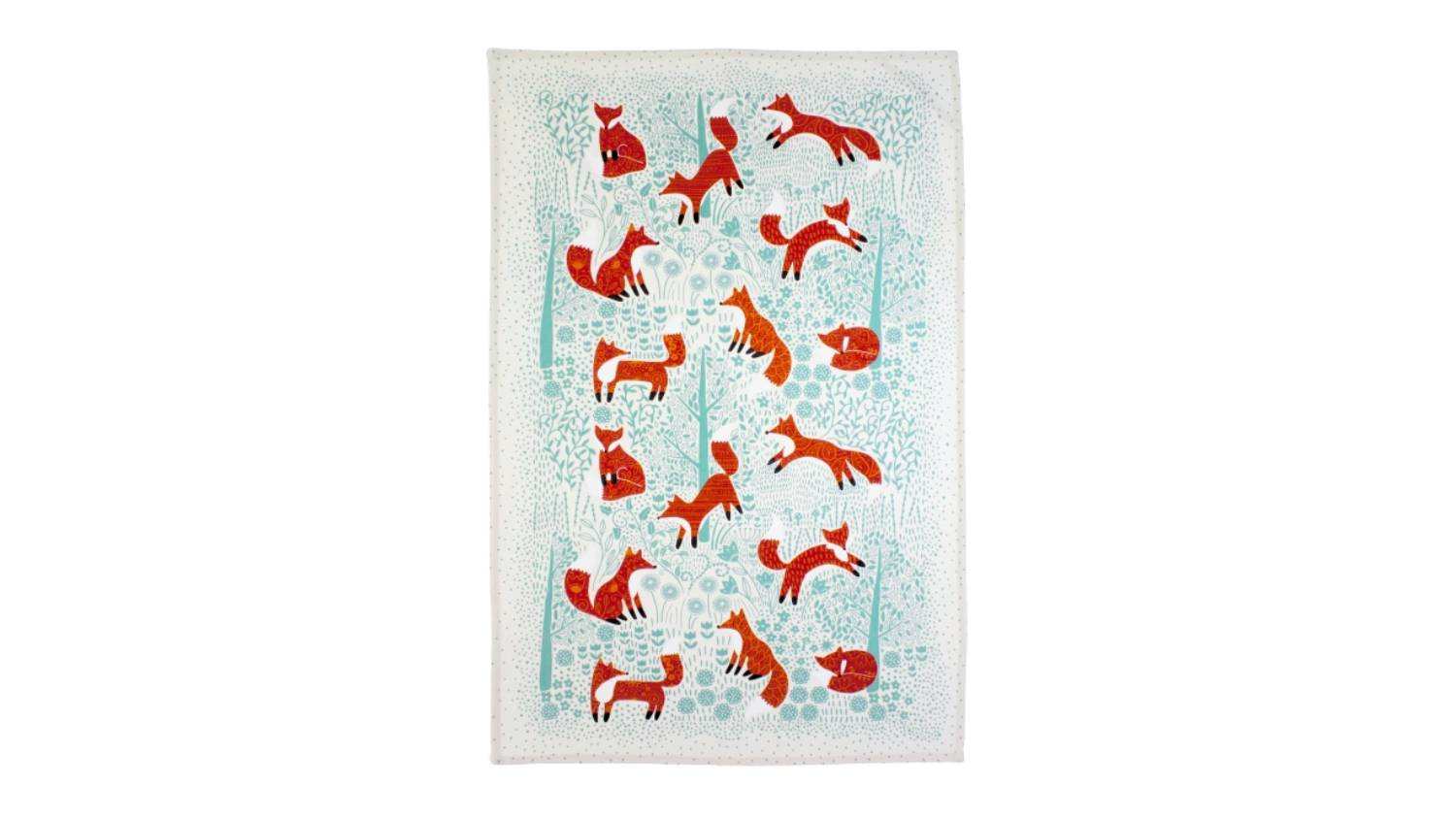 Cotton tea towel with red foxes in various poses on a light blue background with tree motifs
