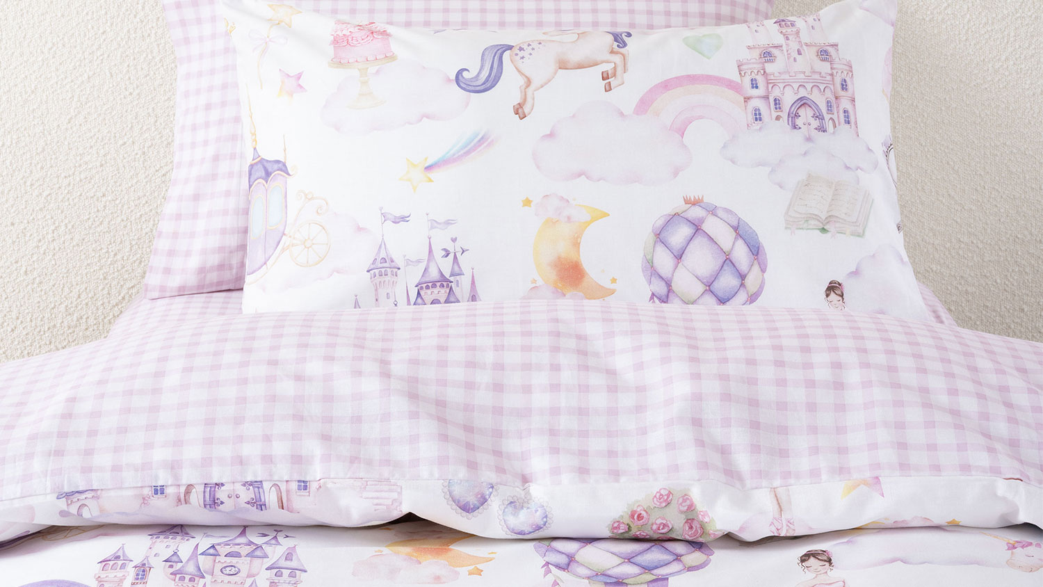 A unicorn stardust duvet cover set in a kids room, showing castles, hot air balloons, ballerina, unicorns, and more