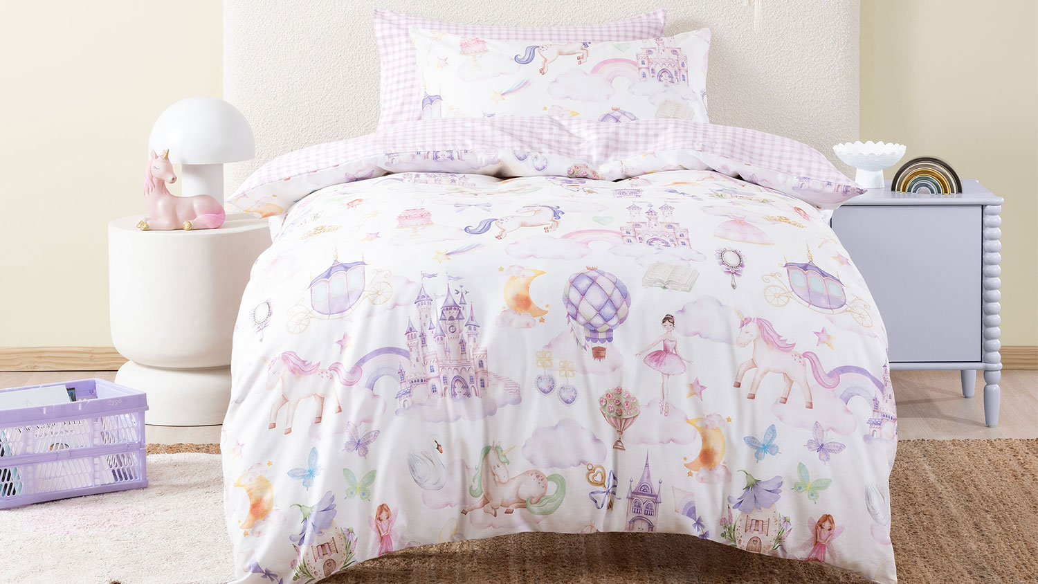 A unicorn stardust duvet cover set in a kids room, showing castles, hot air balloons, ballerina, unicorns, and more