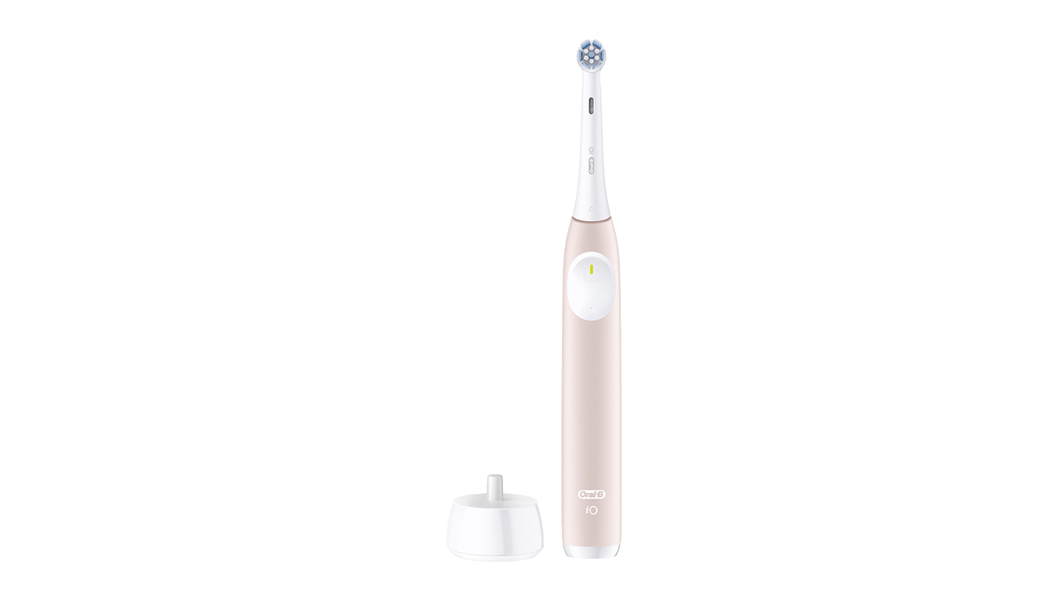 A blush sand Oral-B iO toothbrush beside a white stand on a clean surface