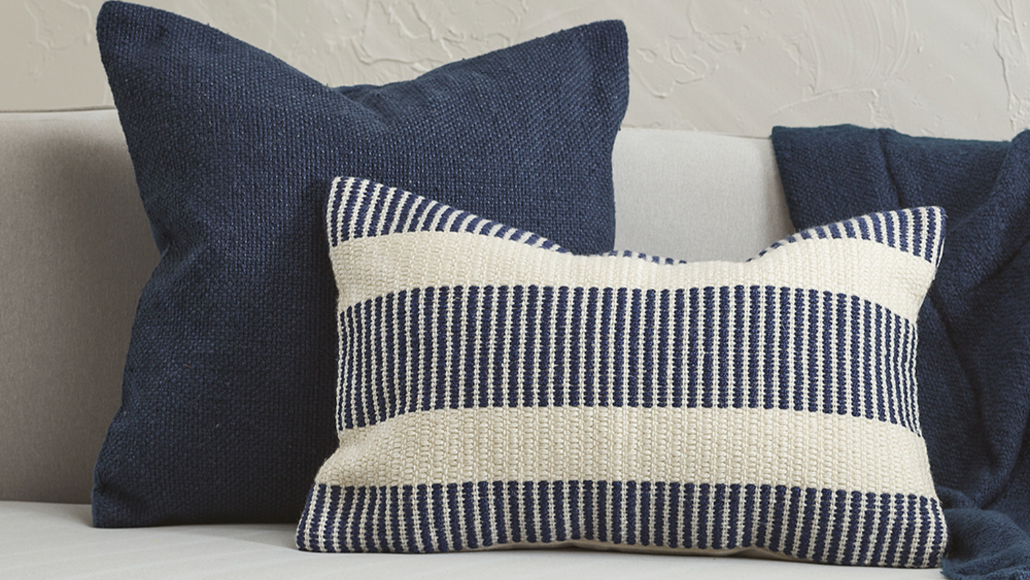 Close-up of a cushion featuring navy blue and white horizontal stripes.