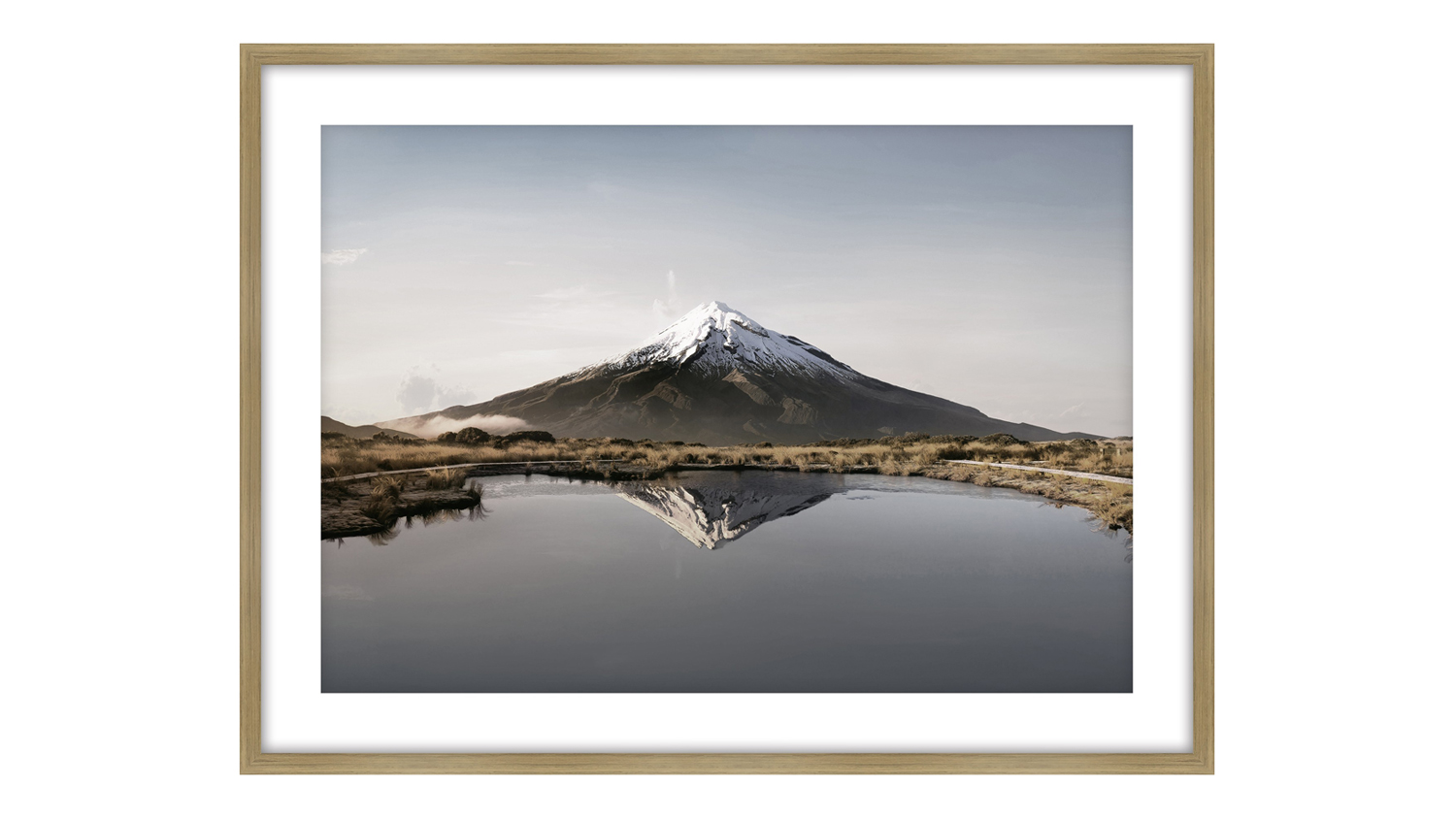 Snow-capped mountain reflected in a calm lake under clear sky.
