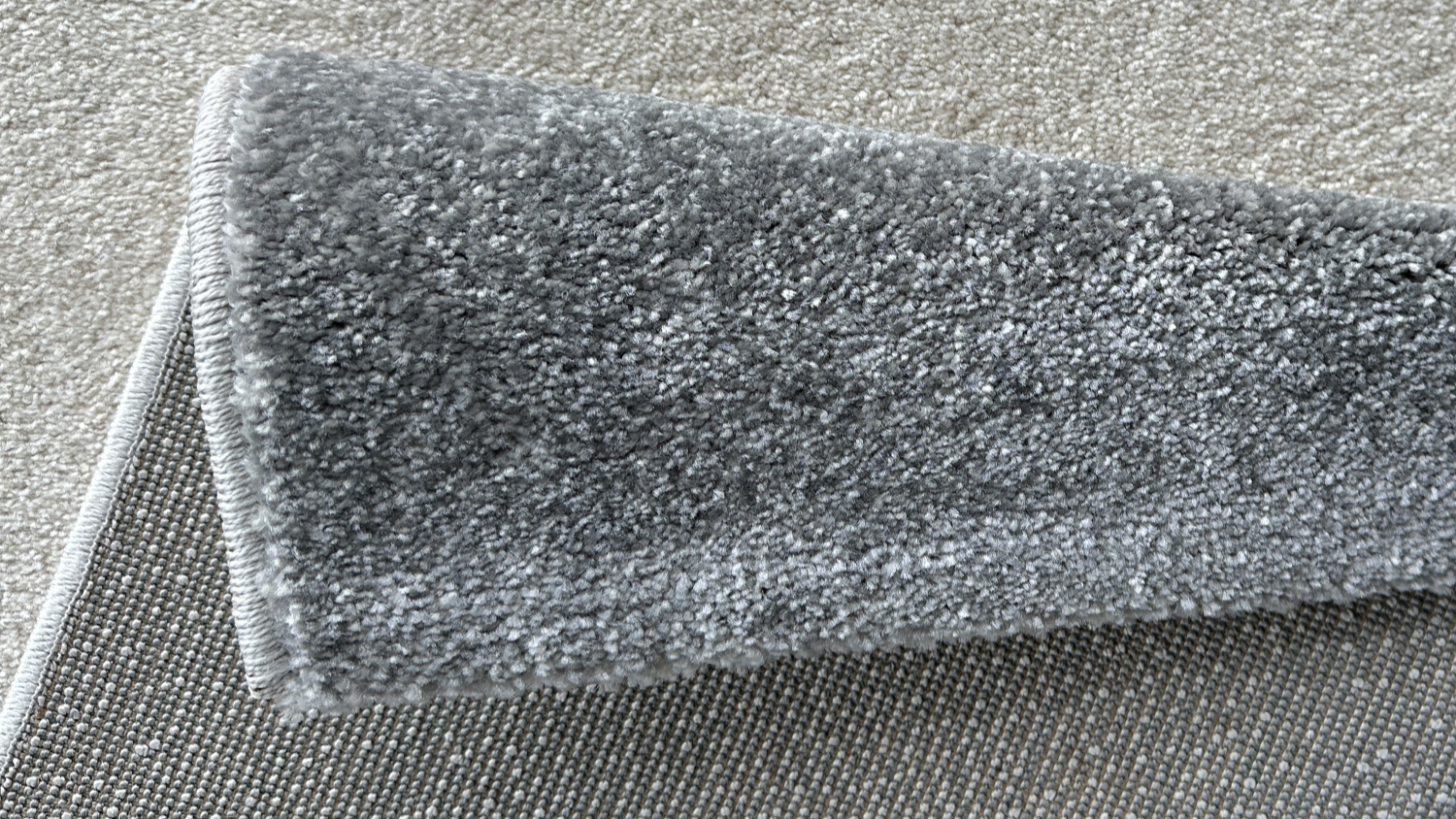 Folded corner of abstract rug showing thickness and texture.