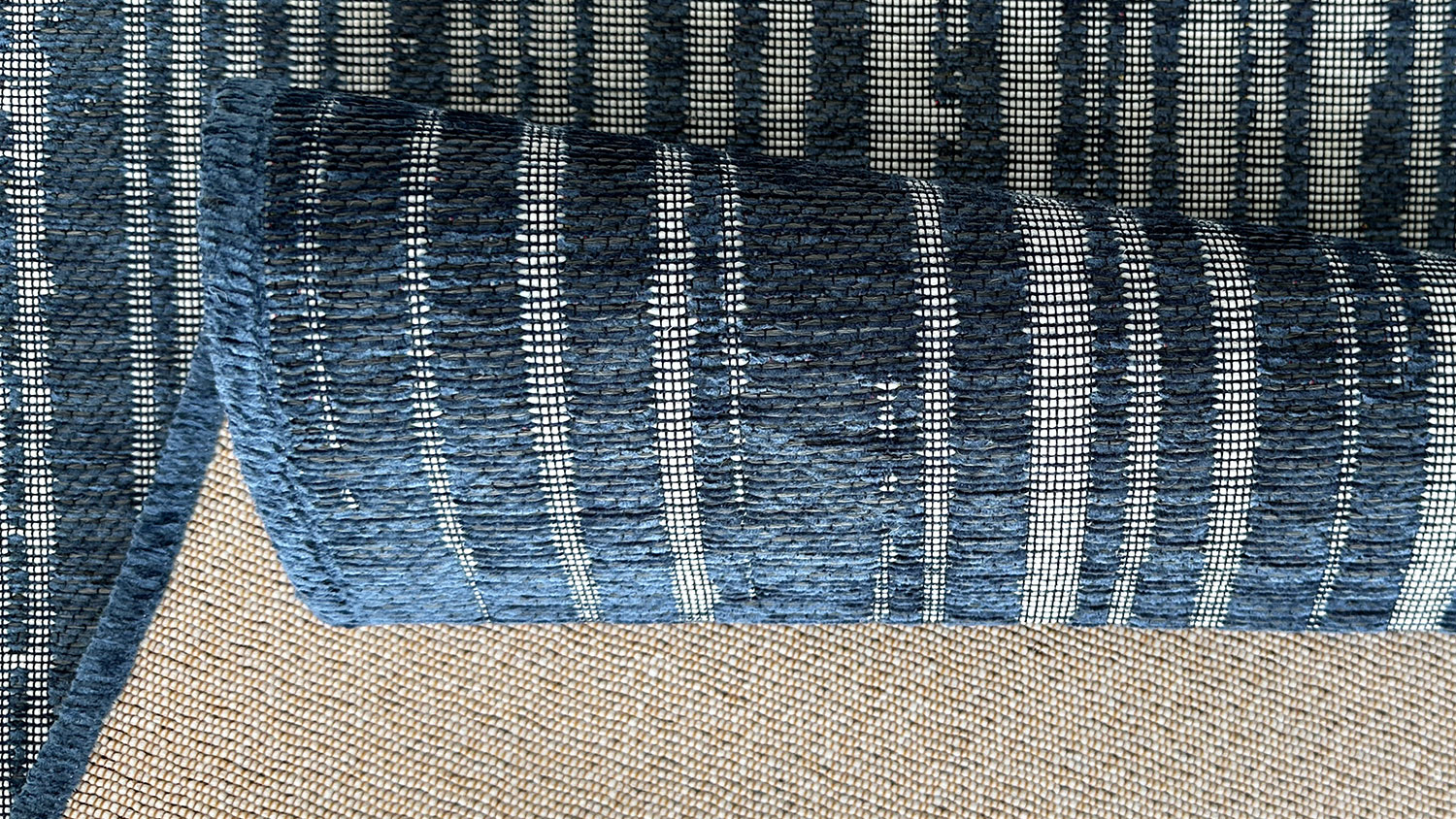 Emilia Liun Outdoor Rug. Striped pattern of uneven line thickness & spacing. Colours blend shades of blue, gray, white creating a textured look.
