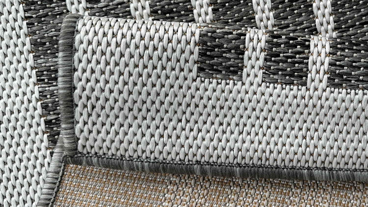 Porto Linha Outdoor Rug. Shows a vertical striped pattern with evenly spaced thin lines in black and gray tones, framed by a light border.