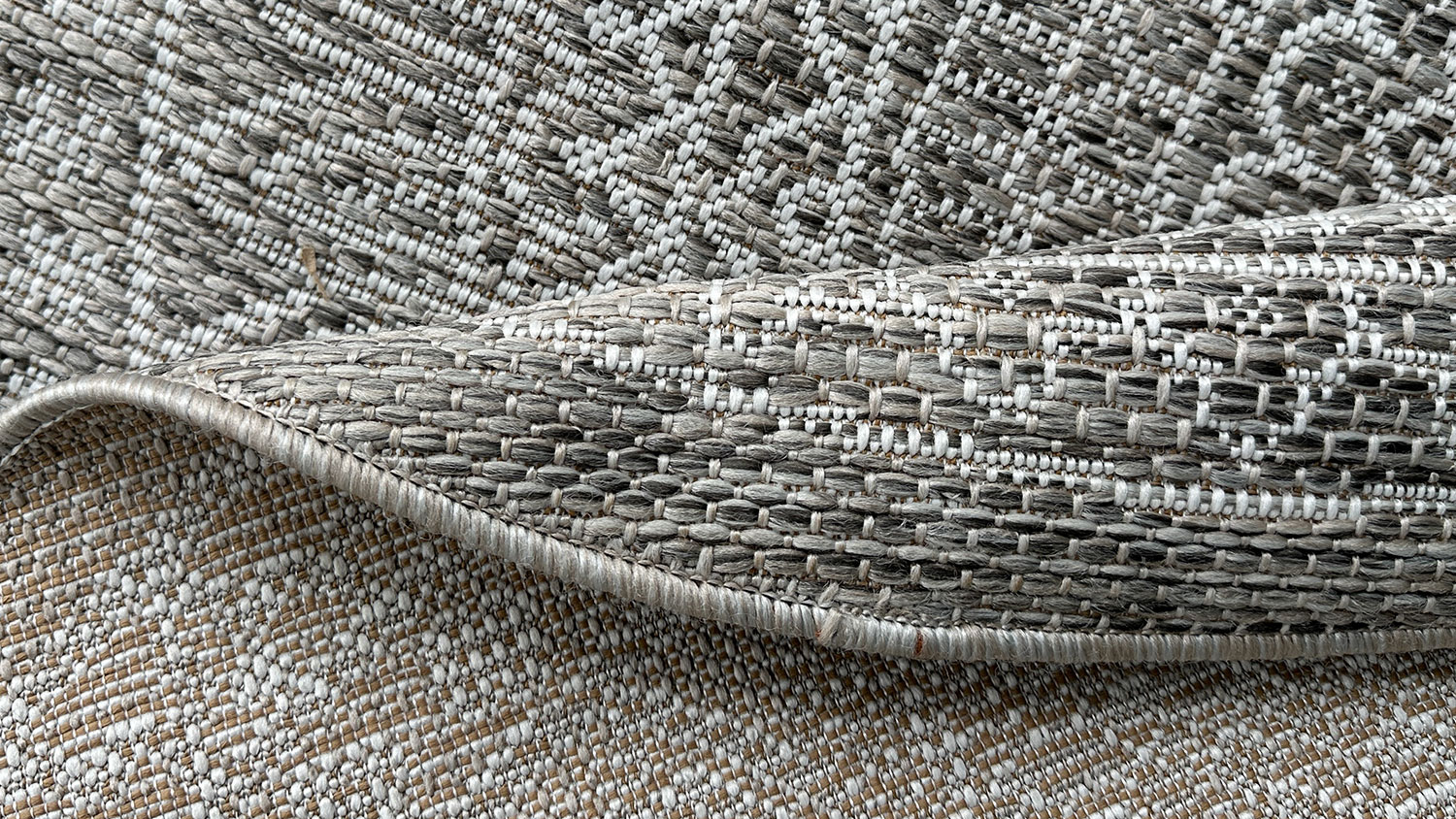 Porto Loom Round Outdoor Rug. Circular pattern with concentric designs made of fine lines, forming a detailed mandala-like texture in gray brown tone.