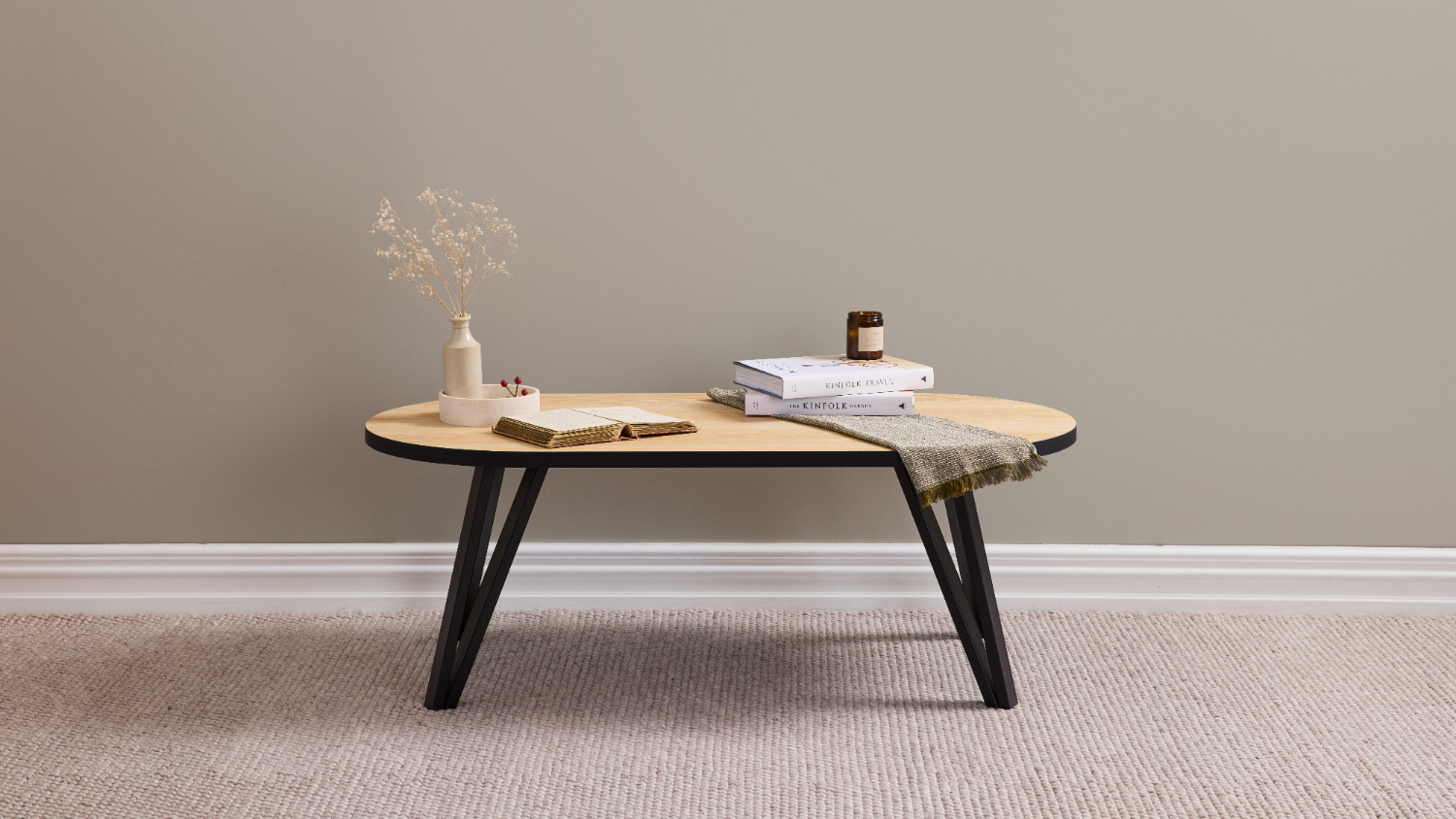 Orb 1200mm Coffee Table in light wood finish with black angled leg on a beige carpet