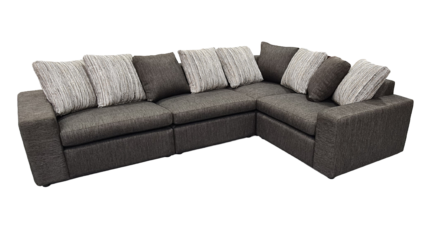 A large, dark gray L-shaped modular sectional sofa with eight gray and striped throw pillows
