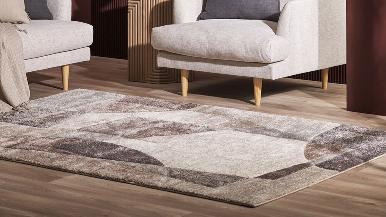 Cassidy Rug in a living room with two light armchairs, featuring an abstract design in cocoa