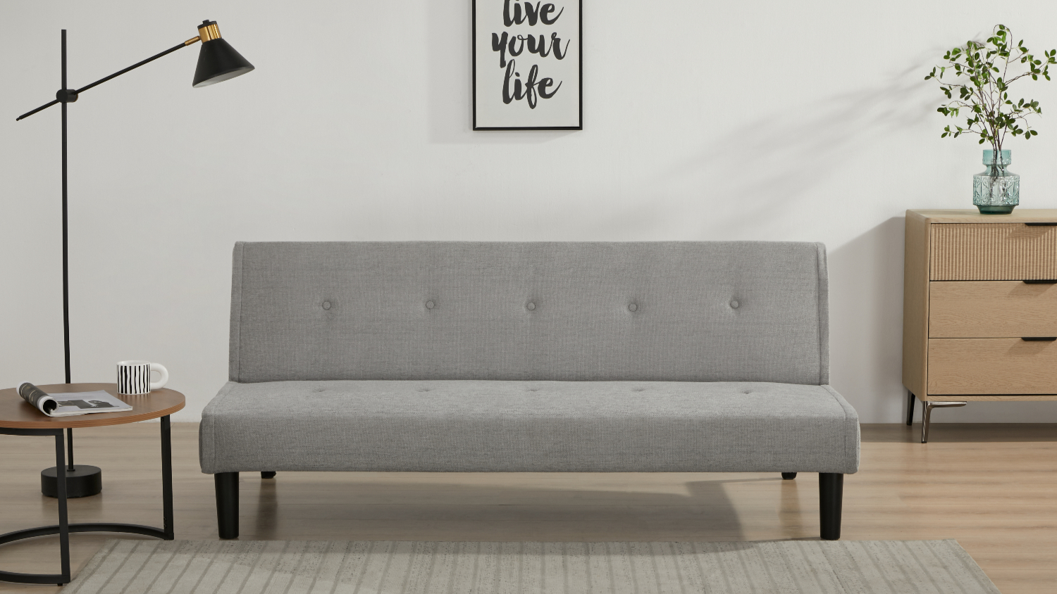 A straight-on view of the Oslo Fabric Sofa Bed in light grey, placed in a minimal living room